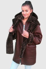 lange Damen Lammfelljacke mit Reißverschluss. Die Schaffell-Jacke kann gewendet werden, abnehmbare Kapuze