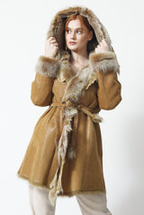 Damen-Lammfellmantel, außen Pelzvelour innen Toskana-Lamm mit Kapuze. Leicht auf Figur gearbeitet Auffällig gearbeitete in der Farbe cognac.